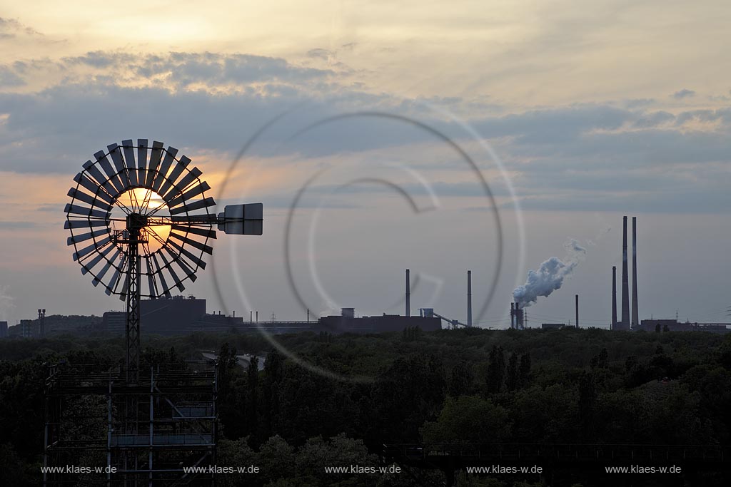 Duisburg Meiderich, der Landschaftspark Duisburg-Nord, auch kurz LaPaDu ist ein etwa 200 Hektar groer Landschaftspark rund um ein stillgelegtes Huettenwerk in Duisburg-Meiderich, das im Rahmen der IBA (Internationale Bauausstellung Emscher Park) entstand. Der Landschaftspark ist einer der Ankerpunkte der Europaeischen Route der Industriekultur sowie der Route der Industriekultur im Ruhrgebiet.  Sonnenuntergang WIndenergieturm, im Hintergrund Kraftwerk Walsum in der Daemmerung; Duisburg-Meiderich, the Meiderich ironworks are the main feature in the North Duisburg Landscape Park