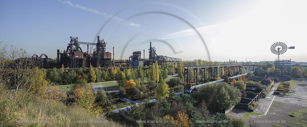 Duisburg Meiderich. Panoramablick mit Hochofen 1, 2 und 5, Erzbunker, Bock-Kran, Bunkeranlage, Windenergieturm, Sintergaerten, Sinterplatz. Der Landschaftspark Duisburg-Nord, auch kurz LaPaDu ist ein etwa 200 Hektar grossr Landschaftspark rund um ein stillgelegtes Huettenwerk in Duisburg-Meiderich, das im Rahmen der IBA (Internationale Bauausstellung Emscher Park) entstand. Der Landschaftspark ist einer der Ankerpunkte der Europaeischen Route der Industriekultur sowie der Route der Industriekultur im Ruhrgebiet; Duisburg-Meiderich, the Meiderich ironworks are the main feature in the North Duisburg Landscape Park, panorama view from blast furnace at left side to the wind turbine tower at right side sintering plant.