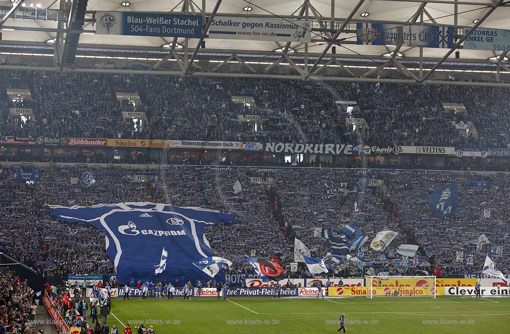 Gelsenkirchen Veltins Arena, Fussballstadion Blick auf Nordkurve mit Fans, Riesentrikot, Schals und Fahnen vor einem Fussball Bundesliga Spiel des FC Schalke 04; Gelsenkirchen football stadium of FC Schalke 04 Fans and flaggsl