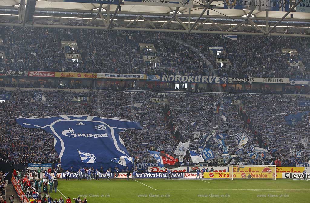 Gelsenkirchen Veltins Arena, Fussballstadion Blick auf Nordkurve mit Fans, Riesentrikot, Schals und Fahnen vor einem Fussball Bundesliga Spiel des FC Schalke 04; Gelsenkirchen football stadium of FC Schalke 04 Fans and flaggsl