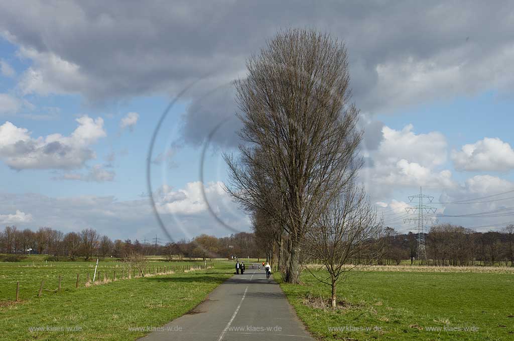 Kemnader See, Landschaft mit Weg und Fussgaengern, Fahrradfahrern Cumuluswolken weiss grau in Fruehlinhslandschaft mit kahlen Baeumen; Landscape near lake Kemnade in springtime with bikers and wlakers, bare.branched trees, cumulus clouds 