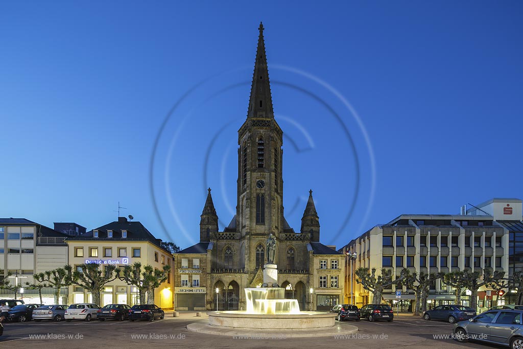 Saarlouis, St. Ludwig, katholische Kirche am Grossen Markt mit Marienbrunnen zur blauen Stunde. Das etwa 30 m hohe Bauwerk wurde in den 1960er Jahren nach Plaenen von "Gottfried Boehm" unter Verwendung von Ueberresten der Vorgaengerbauten errichtet; Saarlouis, St. Ludwig, catholic church at the square Grosser Markt with fountain Marienbrunnen at blue hour.