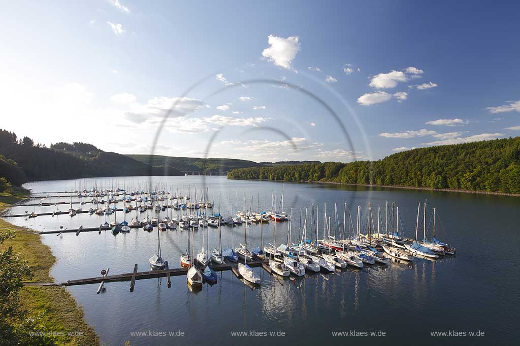 Olpe Sondern Blick auf den Biggesee mit Segelbooten an der Anlegestelle in Sondern bei klarer Sicht, blauer Himmel, klene Kumuluswolken; Sailboats docked at haven in Olpe-Sondern at lake Bigge in summer landscape in the aftenoon, blue sky, some cumulus clouds