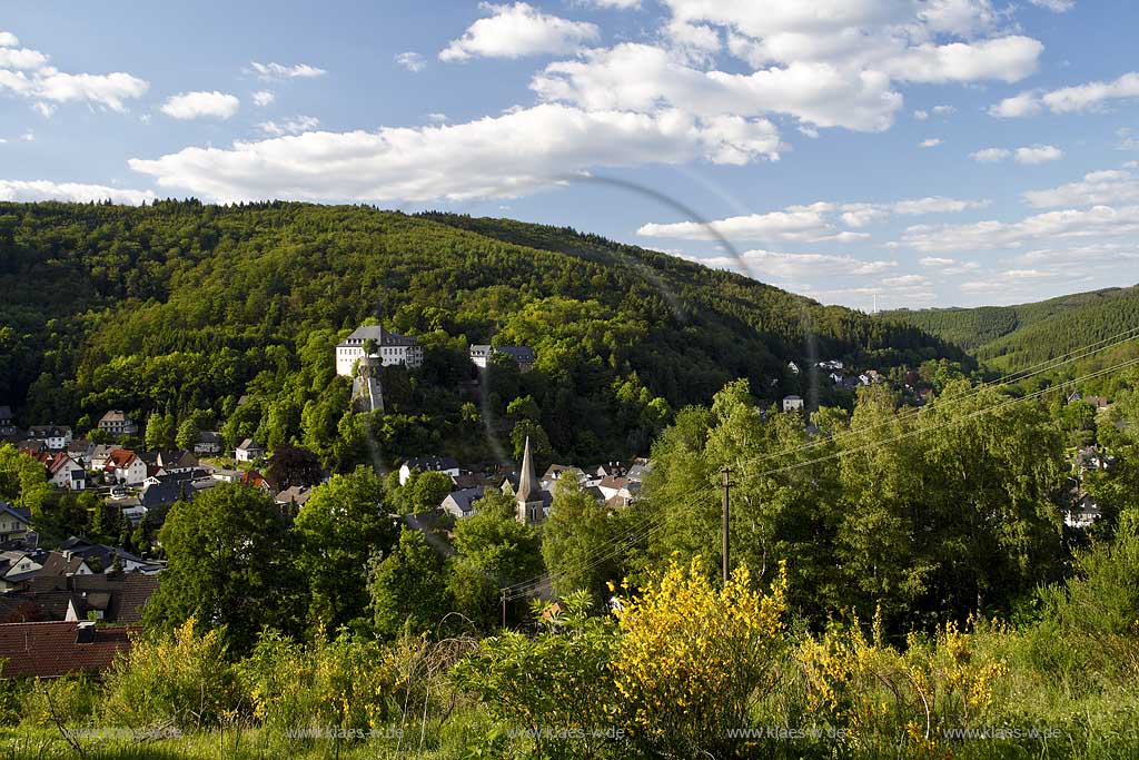 Lennestadt Bilstein Blick mit Ort und Burg Bilstein, Deutsche Jugendherberge in Sommerlandschaft mit Kumuluswolken mit  bluehendem Ginsterland; View to village and castle Bilstein (german youth hostel) with blue sky and cumulus clouds and bloom gorse, furze in flower