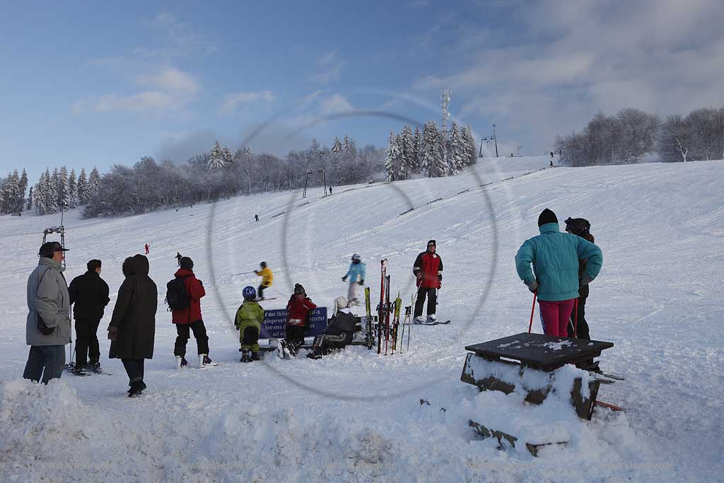 Sundern Wildewiese, Skigebiet mit Skipiste Lift und Skifahrern am verschneiten Hang des Schomberg mit Skilift und Mobilfunkmast, -turm im Winter; Skiing region Wildewiese with skier and ski tourists at the downhill of Schomberg with ski lift and mobilephone mast in Sundern-Wildewiese