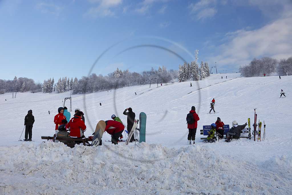 Sundern Wildewiese, Skigebiet mit Skipiste Lift und Skifahrern am verschneiten Hang des Schomberg mit Skilift und Mobilfunkmast, -turm im Winter; Skiing region Wildewiese with skier and ski tourists at the downhill of Schomberg with ski lift and mobilephone mast in Sundern-Wildewiese