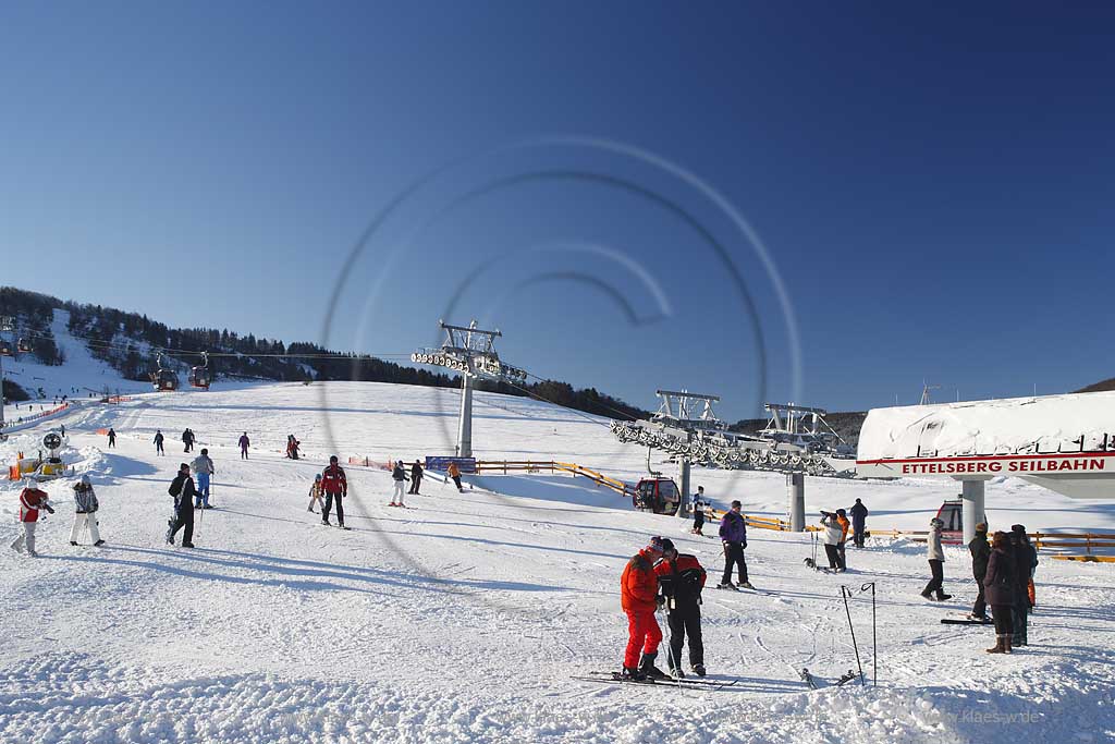 Willingen Upland Etttelsberg Seilbahn mit vielen Menschen Skifahrern auf der Skipiste und an der Seilbahn; Ettelsberg aerial tramway with a lot of traffic of ski and snowboard drivers in snow covered landscape