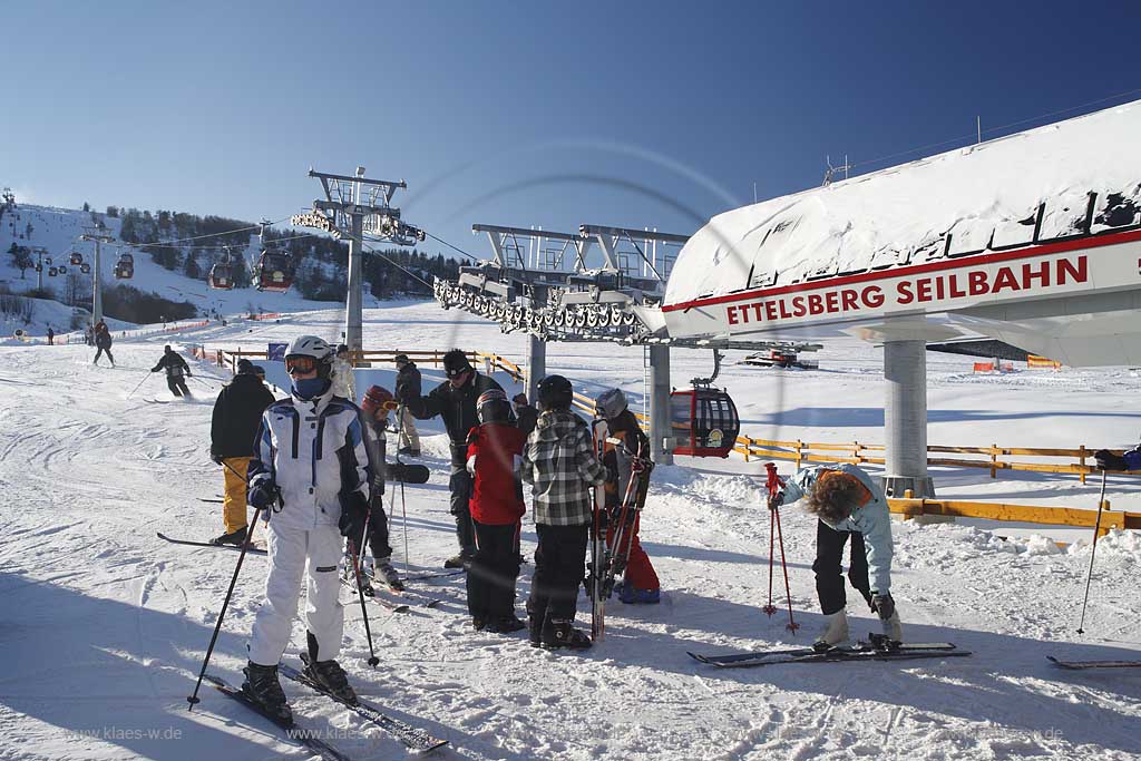 Willingen Upland Etttelsberg Seilbahn mit vielen Menschen Skifahrern auf der Skipiste und an der Seilbahn; Ettelsberg aerial tramway with a lot of traffic of ski and snowboard drivers in snow covered landscape