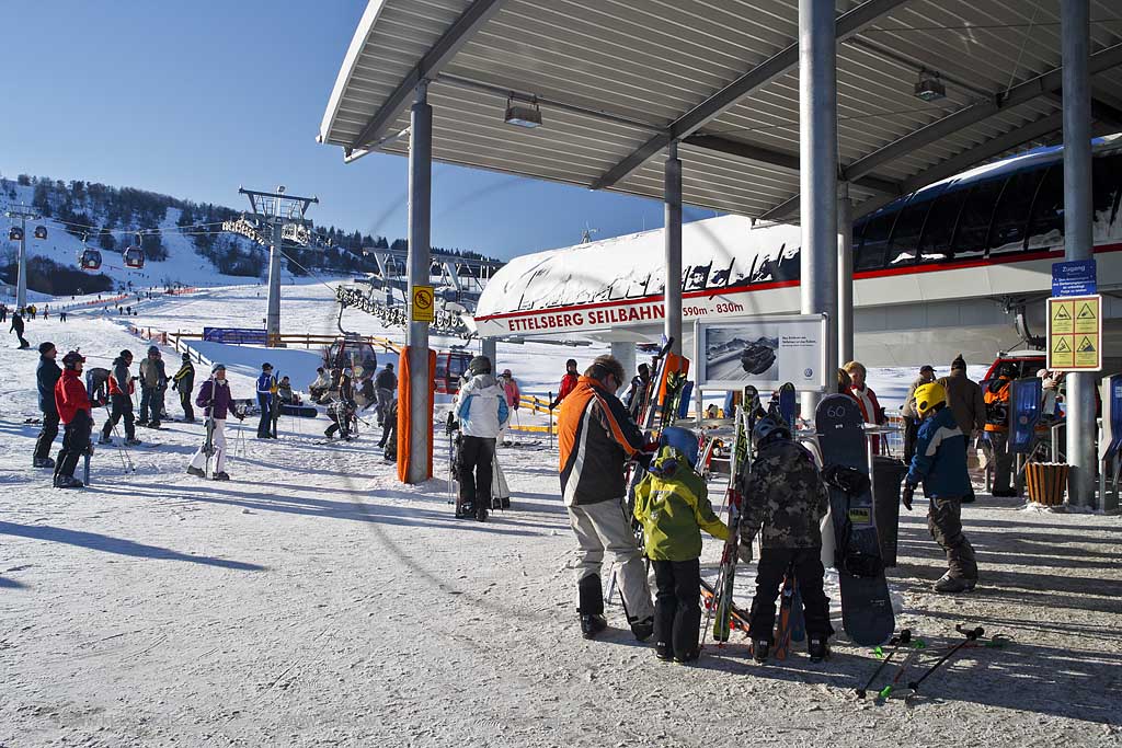 Willingen Upland Etttelsberg Seilbahn mit vielen Menschen Skifahrern auf der Skipiste und an der Seilbahn; Ettelsberg aerial tramway with a lot of traffic of ski and snowboard drivers in snow covered landscape