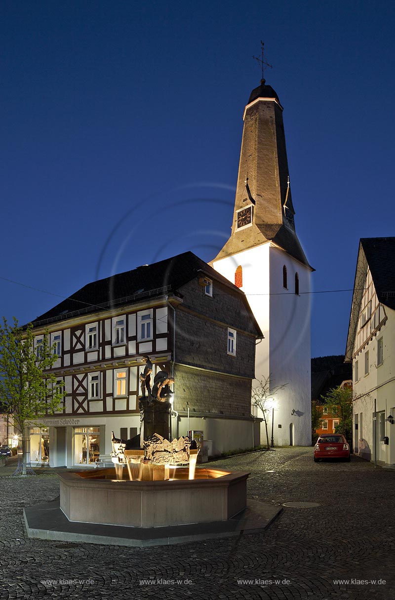 Bad Laasphe, Abendstimmung am Kirchplatz mit Altstadtbrunnen und Turm der evangelischen Kirche aus dem 13. Jahrhundert zur blauen Stunde; Bad Laasphe, view with fountain and tower of the  late romance church from 13th century during blue hour