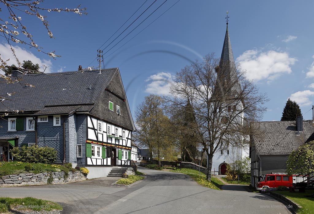 Freudenberg Oberhoklzklau, Pfarrhaus, das aelteste Fachwerkhaus des Siegerlandes, von 1608, rechts der Turm der evangelischen Pfarrkirche, einer suedwestfaelischen Hallenkirche im Fruehling; Freudenberg Oberholzklau, the oldes framework house in the Siegerland,  from 1608 and the tower of  parish church