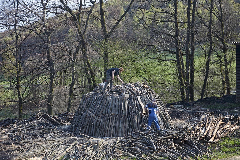 Netphen Walpersdorf, Kohlenmeiler Walpersdorf, einziger noch betriebener Kohlenmeiler im Siegerland. Die Koehlerei zur Herstellung von Holzkohle hat im Siegerland auf Grund der Eisenverhuettung eine lange Tradition; Netphan Walpersdorf traditional charcoal kiln in springtime landscape