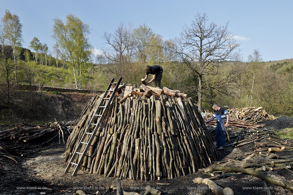 Netphen Walpersdorf, Kohlenmeiler Walpersdorf, einziger noch betriebener Kohlenmeiler im Siegerland. Die Koehlerei zur Herstellung von Holzkohle hat im Siegerland auf Grund der Eisenverhuettung eine lange Tradition; Netphan Walpersdorf traditional charcoal kiln in springtime landscape
