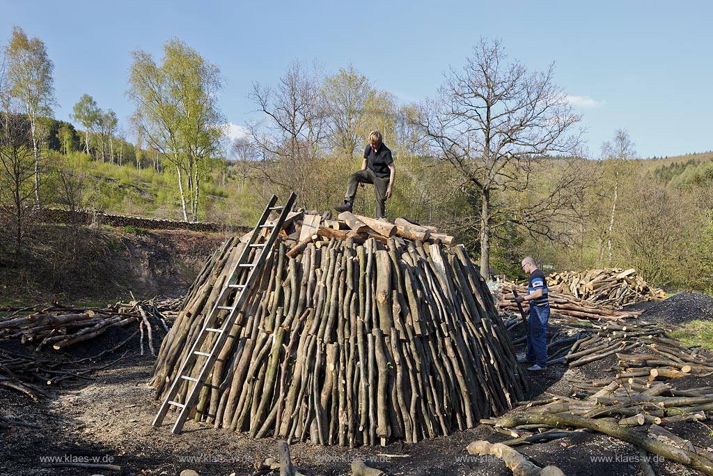 Netphen Walpersdorf, Kohlenmeiler Walpersdorf, einziger noch betriebener Kohlenmeiler im Siegerland. Die Koehlerei zur Herstellung von Holzkohle hat im Siegerland auf Grund der Eisenverhuettung eine lange Tradition; Netphan Walpersdorf traditional charcoal kiln in springtime landscape