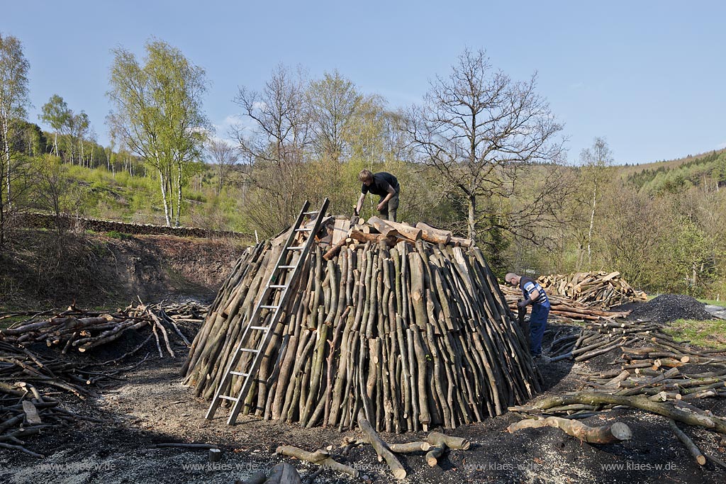 Netphen Walpersdorf, Kohlenmeiler Walpersdorf, einziger noch betriebener Kohlenmeiler im Siegerland. Die Koehlerei zur Herstellung von Holzkohle hat im Siegerland auf Grund der Eisenverhuettung eine lange Tradition; Netphan Walpersdorf traditional charcoal kiln in springtime landscape