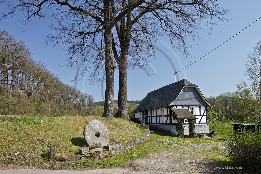 Wilnsdorf Niederdielfen Wassermuehle mit Muehlstein.  Die landschaftlich schn gelegene Niederdielfener Wasseruehle ist ein Paradebeispiel fr die Muehlentechnik zu Beginn des 18. Jahrhunderts; Wilnsdorf Niederdielfen, half timbered framework watermill with millstone